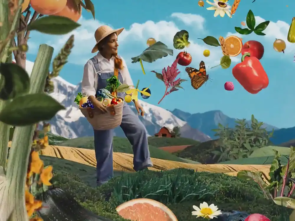 A woman in overalls carries a harvest basket as produce floats over farmland, from Garden of Life's Formulas for Feeling Alive