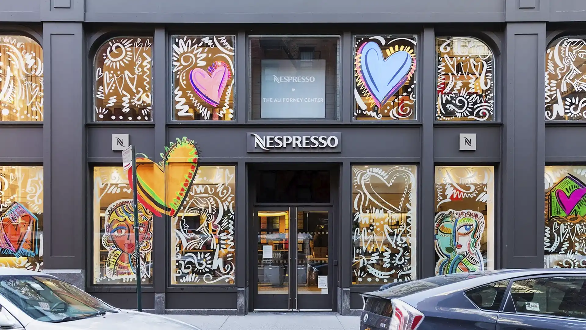 Nespresso boutique windows covered in white line drawings, hearts, and Ali Forney Center signage