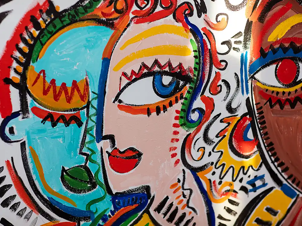 Close-up of colorful painted faces with bold outlines on a boutique window, from Nespresso's Innovation You Can Taste