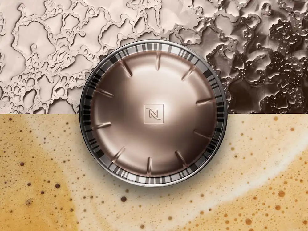 Bronze Nespresso capsule seen from above between crema foam and textured metal, from Innovation You Can Taste