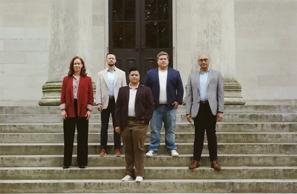 Five people stand on a stone courthouse staircase in The Advocate's coverage of Lambda Legal's All Rise campaign