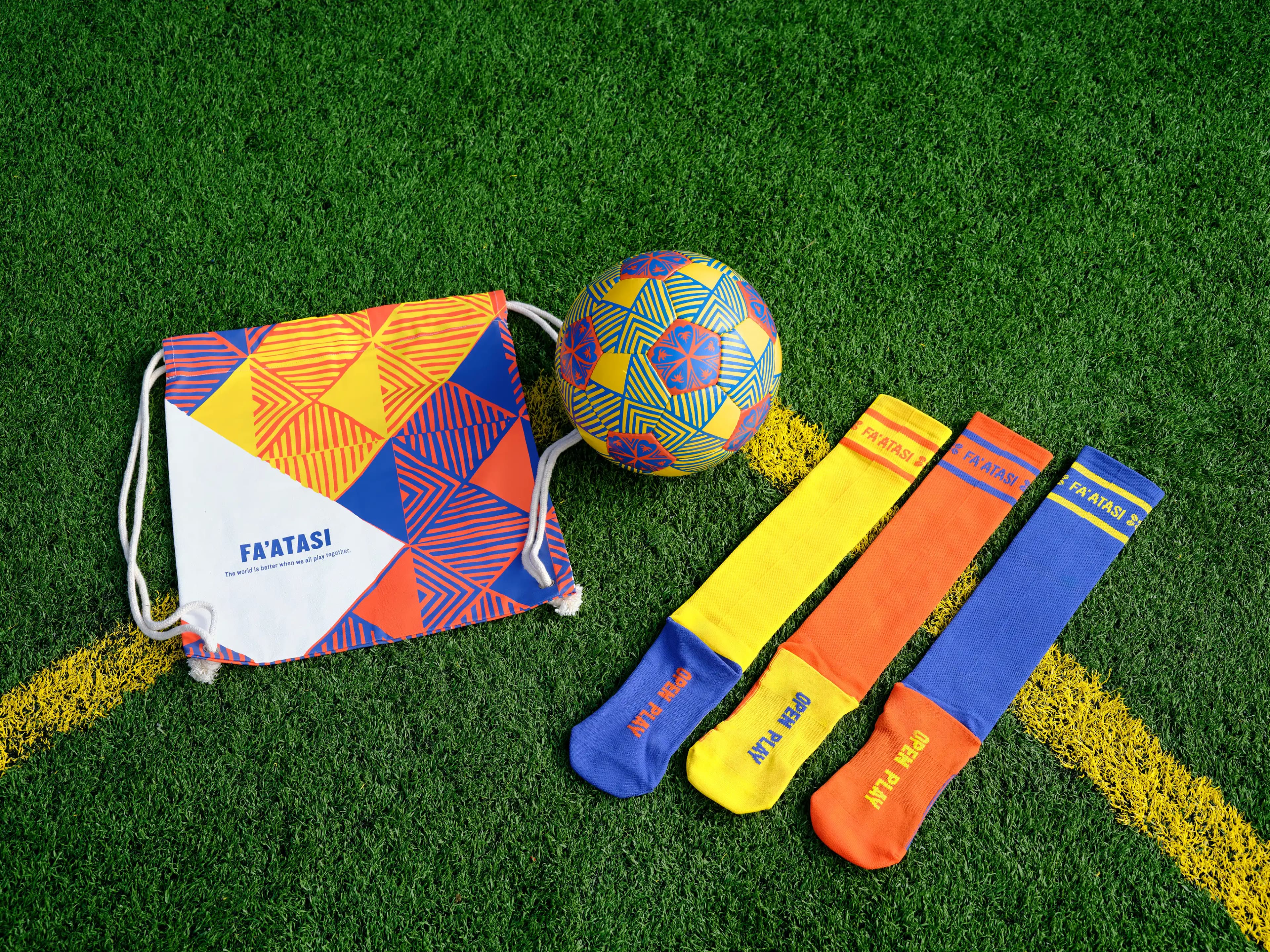 Fa'atasi collection flat lay with drawstring bag, soccer ball, and trio of socks