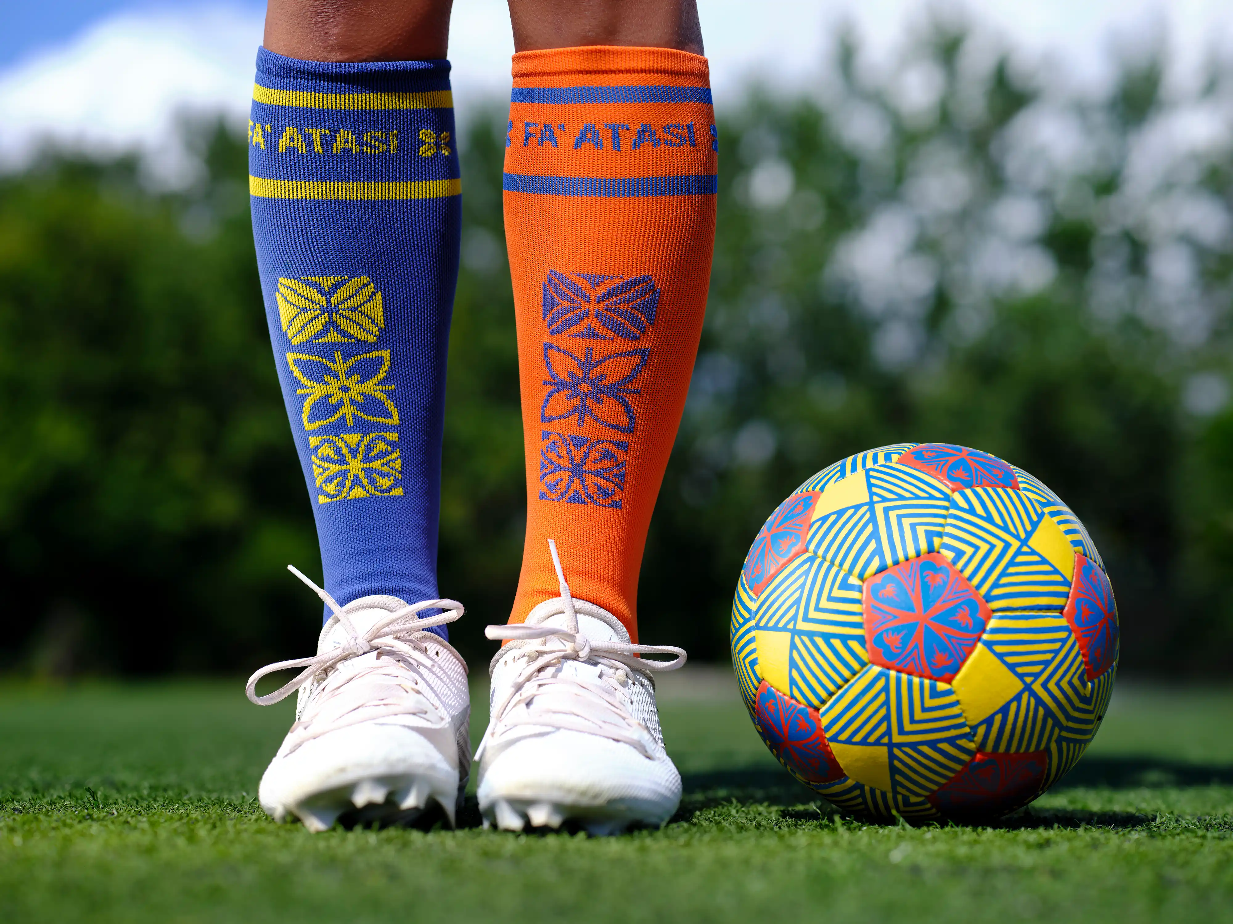 Mismatched blue and orange Fa'atasi soccer socks and a patterned ball on the pitch, from the Next Goal Wins Clio Awards piece